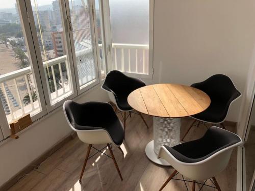 een tafel en 4 stoelen in een kamer met ramen bij State of the Art Apartment in Magaluf