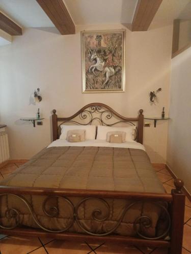 a bed in a bedroom with a painting on the wall at Dimora Garibaldina in Mentana