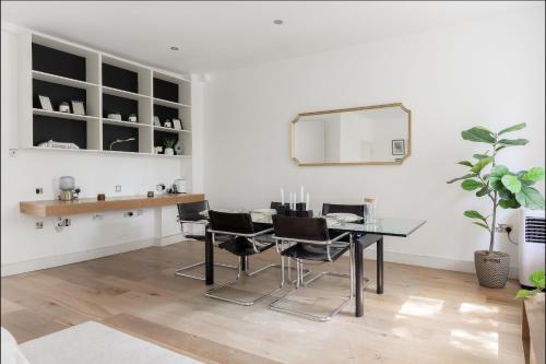 a dining room with a table and chairs and a mirror at Spacious and sunlit 3-bedroom apartment near Paddington Station in London