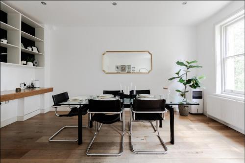 a dining room with a black table and chairs at Spacious and sunlit 3-bedroom apartment near Paddington Station in London