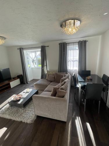 Frobisher Apartment في Erith: غرفة معيشة مع أريكة وطاولة