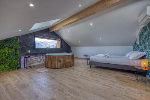 - une chambre avec un lit et une table en bois dans l'établissement La Maison des Eymes - Jacuzzi / Coin Calme, à Saint-Nazaire