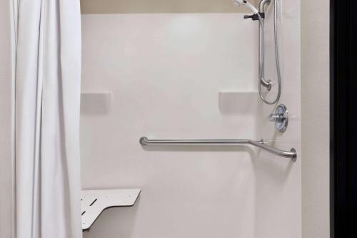 y baño con cortina de ducha y aseo. en Travelodge by Wyndham McAlester, en McAlester