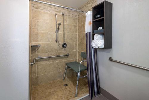 La salle de bains est pourvue d'une douche et d'une chaise. dans l'établissement La Quinta by Wyndham Covington, à Covington