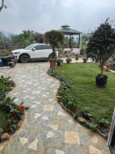 a car parked in a driveway with a garden at Homestay 68 Hoà Bình in Hanoi