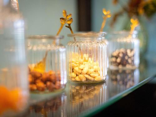 a group of jars filled with different types of nuts at Hôtel Mercure Rochefort La Corderie Royale in Rochefort