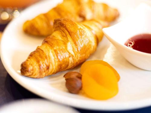 a plate of food with croissants and nuts on a table at Hôtel Mercure Rochefort La Corderie Royale in Rochefort