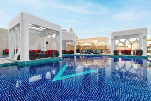 a pool at a resort with a swimming pool at V Hotel Dubai, Curio Collection by Hilton in Dubai