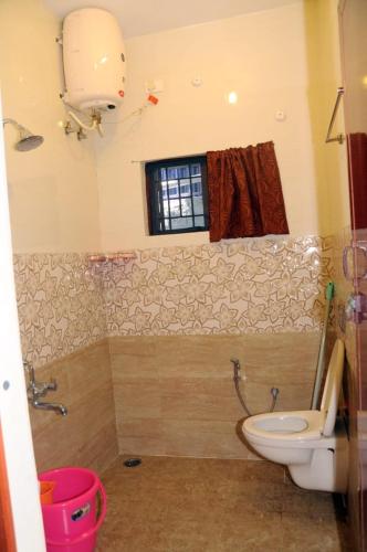 a bathroom with a toilet and a window at Franc Villa - Kothagiri in Kotagiri