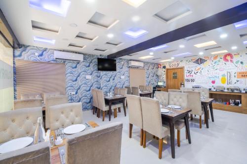 a restaurant with tables and chairs and a tv at Lemonridge Hotels Kukatpally in Hyderabad