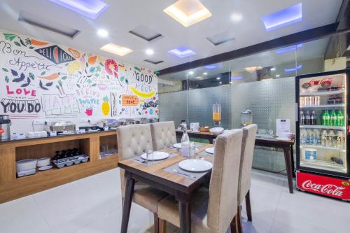 a restaurant with a table and chairs and a counter at Lemonridge Hotels Kukatpally in Hyderabad