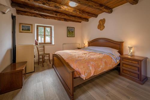 1 dormitorio con cama y techo de madera en Albergo Diffuso Forgaria Monte Prat, en Forgaria nel Friuli