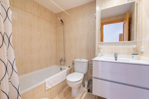 a bathroom with a toilet and a sink and a tub at Apartamento Olot in Pollença