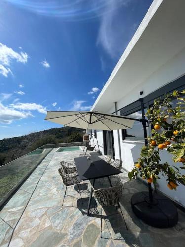 a patio with a table and chairs and an umbrella at Southern Crete Panoramic House in Heraklion