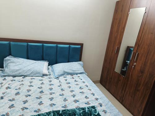 Bett mit blauem Kopfteil in einem Schlafzimmer in der Unterkunft Akansha Deep heights in Kota