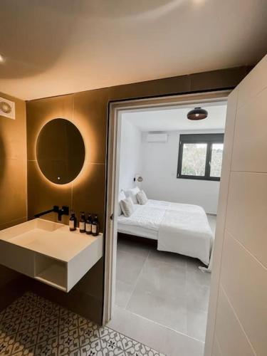 a bedroom with a bed and a bathroom with a sink at Southern Crete Panoramic House in Heraklion
