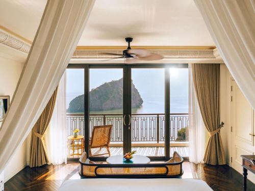 um quarto com uma grande janela com vista para o oceano em Hôtel Perle d'Orient Cat Ba - MGallery em Ilha de Cát Bà