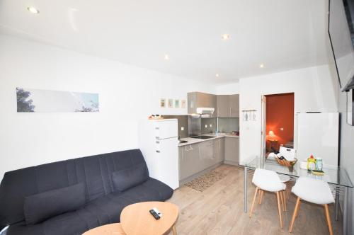 un salon avec un canapé et une cuisine dans l'établissement Petite maison tout confort, à Leucate