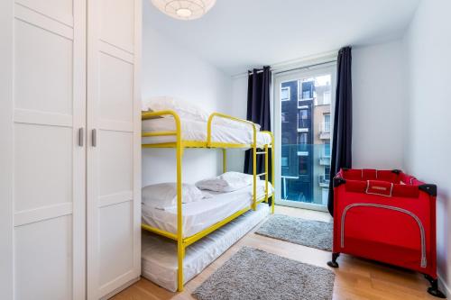 een slaapkamer met een geel stapelbed en een rode koffer bij Lichtrijk & ruim app aan zee met zonneterras - 6p in Wenduine
