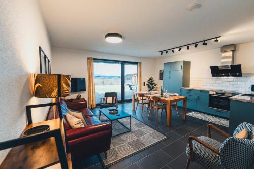 a living room with a couch and a table at Hunsrück Valley View Apartment with Cedar SAUNA in Bruschied