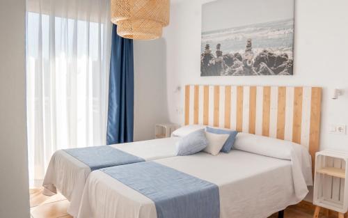 a bedroom with two beds and a painting on the wall at Camping La Masia - Maeva Vacansoleil in Blanes