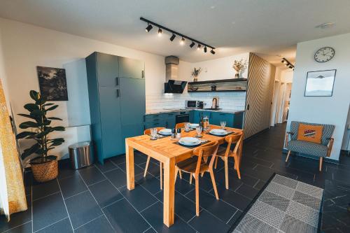a kitchen with a wooden table and chairs in a room at Hunsrück Valley View Apartment with Cedar SAUNA in Bruschied