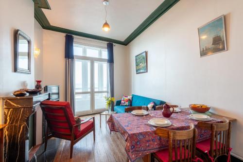 un salon avec une table et des chaises rouges dans l'établissement L'Écho de la Mer 4 - Quartier Rampe des Gobelins, au Tréport