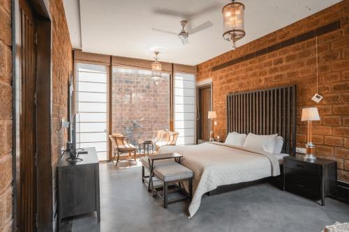- une chambre avec un lit et un mur en briques dans l'établissement Elivaas Glass Villa Ultra Luxe 4BHK with Pvt Pool in Aldona, à Goa