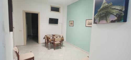 a dining room with a table and chairs and a painting at Casa Gaia in Palermo
