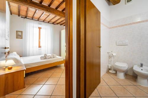 Un baño con una cama, un inodoro y un lavabo. en Arnolfo Tuscany House, en Colle Val D'Elsa