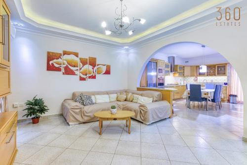 een woonkamer met een bank en een tafel bij Charming 3BR Apt with Breathtaking Sea Views by 360 Estates in Birżebbuġa