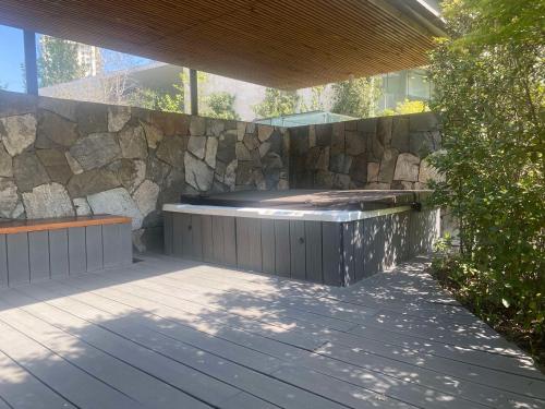 a patio with a stone wall and a hot tub at DoubleTree by Hilton Santiago Kennedy, Chile in Santiago
