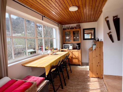 uma cozinha com uma longa mesa de madeira e algumas cadeiras em ALCHYMISTA MINING HOUSE em Spania Dolina