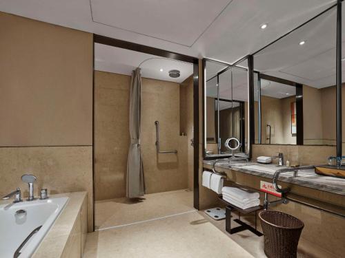uma casa de banho com uma banheira e um lavatório e uma banheira em Doubletree By Hilton Baoding em Baoding