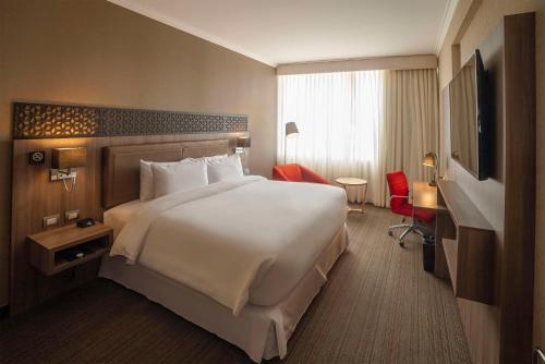 una camera d'albergo con un grande letto e una TV di Doubletree By Hilton Trujillo a Trujillo