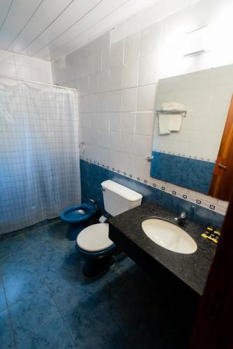 a bathroom with two toilets and a sink and a mirror at HOTEL TROPICAL IGUAZU in Puerto Iguazú