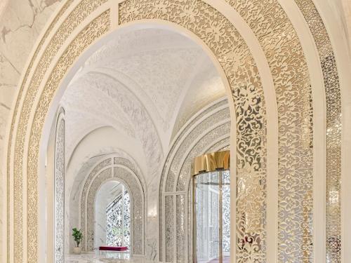 ozdobny korytarz z łukowymi sufitami i oknami w obiekcie Raffles Doha w mieście Doha