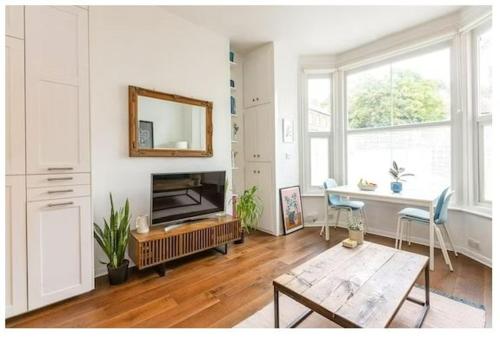 un soggiorno con camino e tavolo di Stylish, 2 Bed Apartment, Muswell Hill a Londra