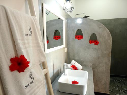 La salle de bains est pourvue d'un lavabo et d'un miroir. dans l'établissement Opera Hotel, à Nungwi