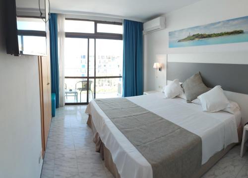 a bedroom with a large bed and a large window at Hotel Amic Miraflores in Can Pastilla