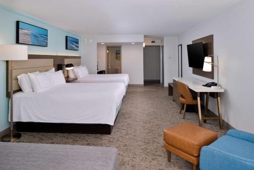 a hotel room with two beds and a desk at DoubleTree by Hilton Corpus Christi Beachfront in Corpus Christi