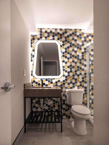 a bathroom with a toilet and a mirror at DoubleTree by Hilton Livermore, CA in Livermore