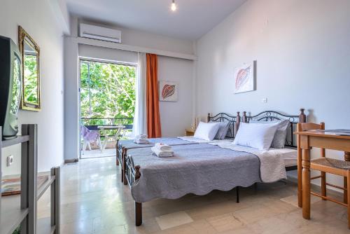 a bedroom with two beds and a large window at Selianitika Bay Apartment B3 in Selianitika