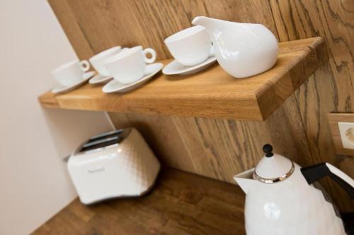a wooden shelf with cups and a toaster on it at Cozy city apartment in Tallinn