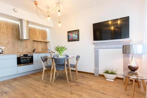 a kitchen with a table and chairs and a tv on the wall at Cozy city apartment in Tallinn
