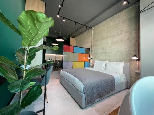 1 dormitorio con cama y planta en Ambassador Skyline Apartments, en Tirana