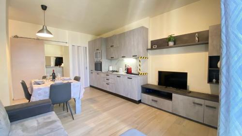 a kitchen with a table and a dining room at Luminoso appartamento Cisanello in Pisa