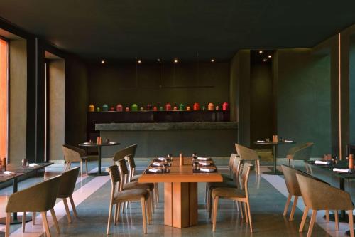 Doubletree By Hilton Ben Guerir Hotel & Residences في Benguerir: مطعم بطاولات وكراسي وكاونتر