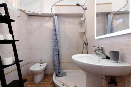 a white bathroom with a sink and a toilet at Apto Pepita - Casa San Marcial in Triana