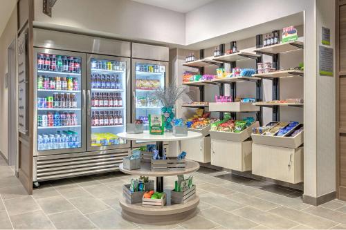 a store aisle with refrigerators and shelves of drinks at Home2 Suites By Hilton Tulsa Airport in Tulsa